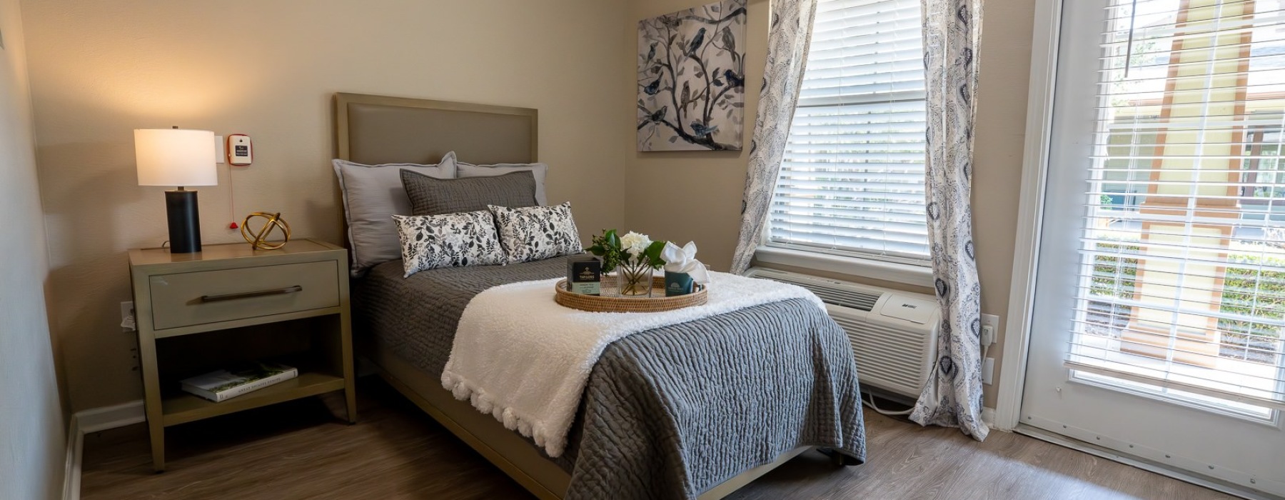 bedroom with a large window and glass door